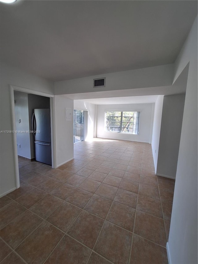 spare room with visible vents and dark tile patterned floors