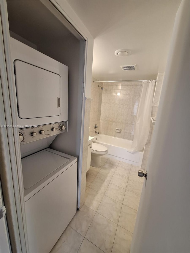 clothes washing area with laundry area, light tile patterned floors, visible vents, and stacked washer / dryer