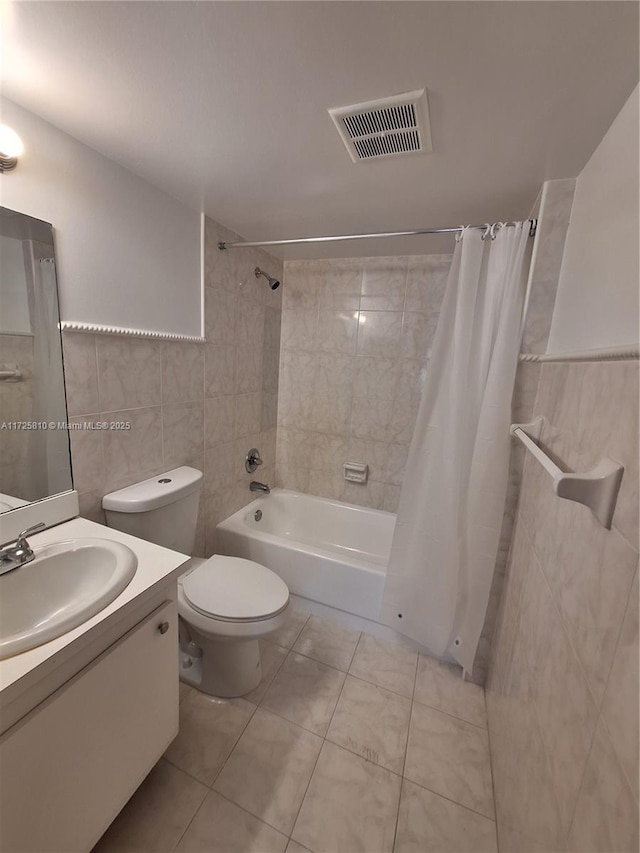 bathroom featuring tile walls, visible vents, toilet, vanity, and tile patterned flooring