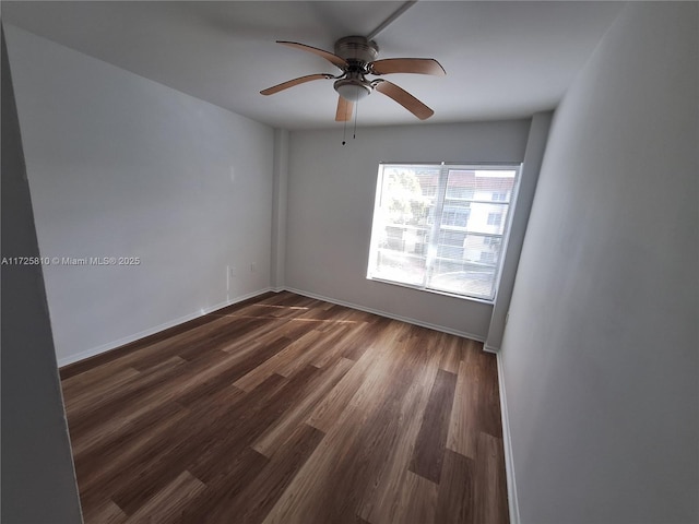 empty room with ceiling fan and dark hardwood / wood-style flooring