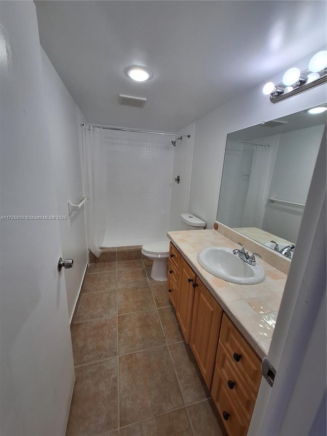 bathroom featuring curtained shower, vanity, and toilet