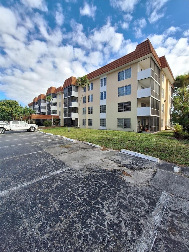 view of building exterior with uncovered parking