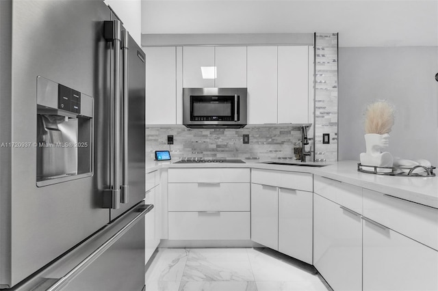 kitchen with white cabinets, appliances with stainless steel finishes, decorative backsplash, and sink