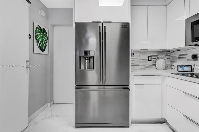 kitchen with white cabinets, appliances with stainless steel finishes, and tasteful backsplash