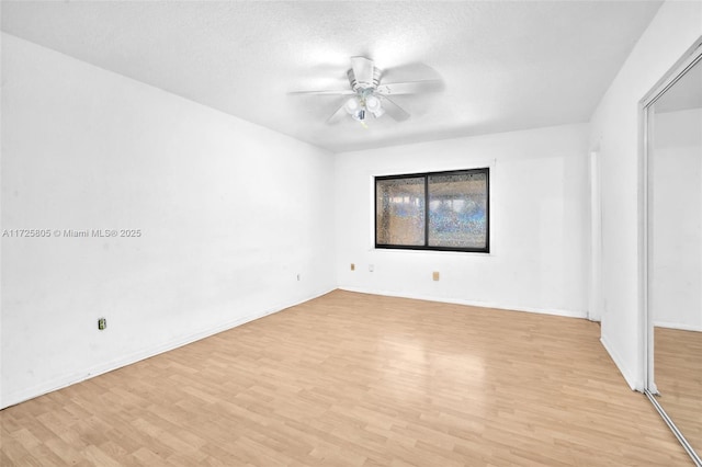 spare room with a textured ceiling, ceiling fan, and light wood-type flooring