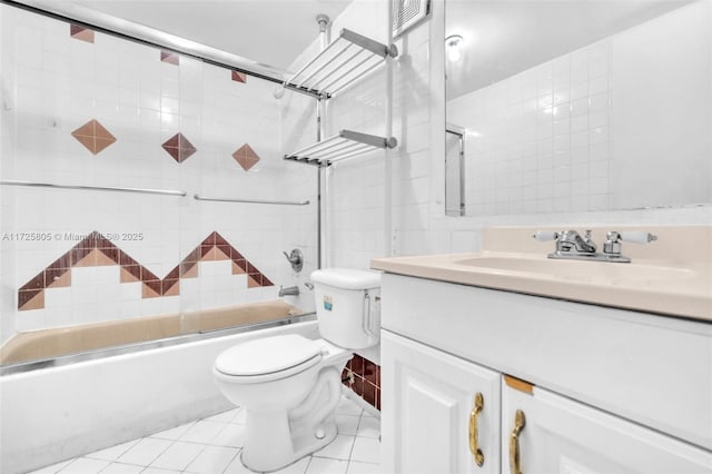 full bathroom featuring tile walls, shower / bath combination with glass door, vanity, toilet, and tile patterned floors