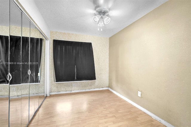 empty room with hardwood / wood-style floors and ceiling fan