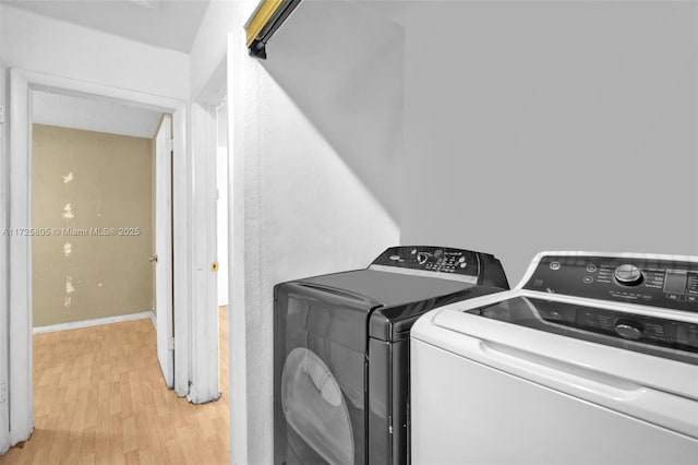 laundry area featuring light hardwood / wood-style flooring and washing machine and dryer