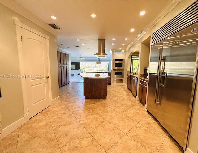 kitchen with crown molding, stainless steel appliances, visible vents, and island range hood