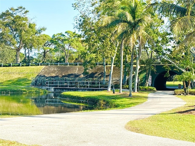 view of home's community with a water view and a yard