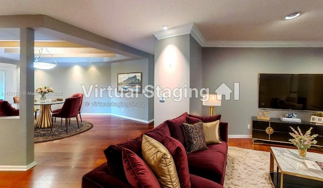 living area with crown molding, wood finished floors, and baseboards