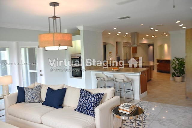 living room with ornamental molding and recessed lighting
