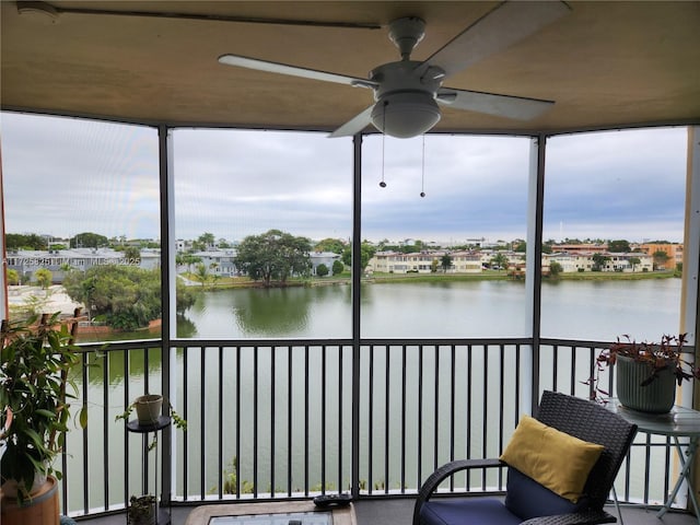 sunroom / solarium with ceiling fan, a wealth of natural light, and a water view