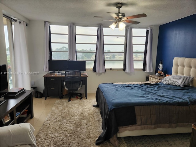 tiled bedroom featuring a textured ceiling and ceiling fan