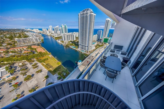 balcony featuring a water view and a city view