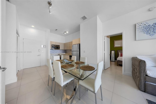 dining room featuring light tile patterned floors, baseboards, and visible vents