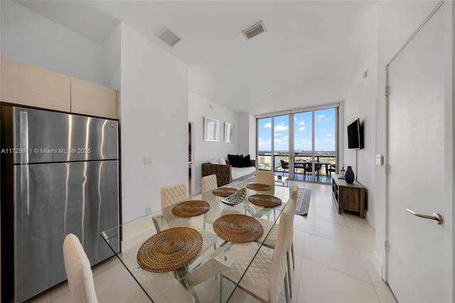 dining space with light tile patterned flooring, visible vents, and floor to ceiling windows