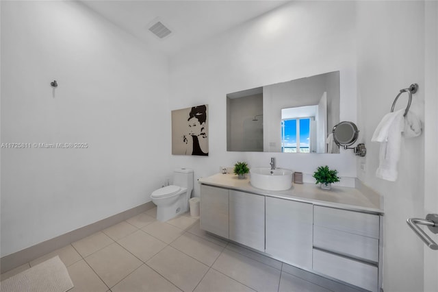 bathroom featuring vanity, baseboards, visible vents, tile patterned floors, and toilet