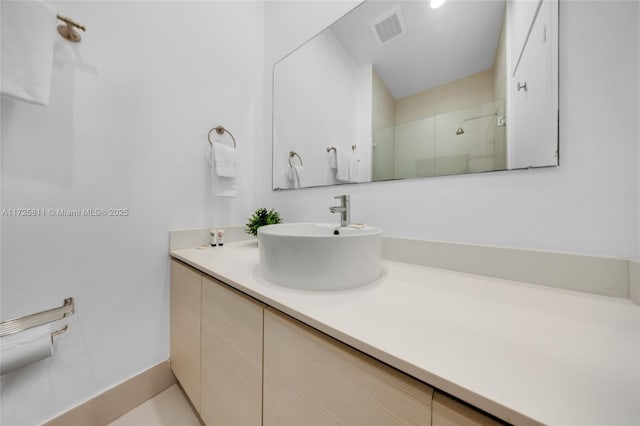 bathroom with visible vents, a shower stall, and vanity