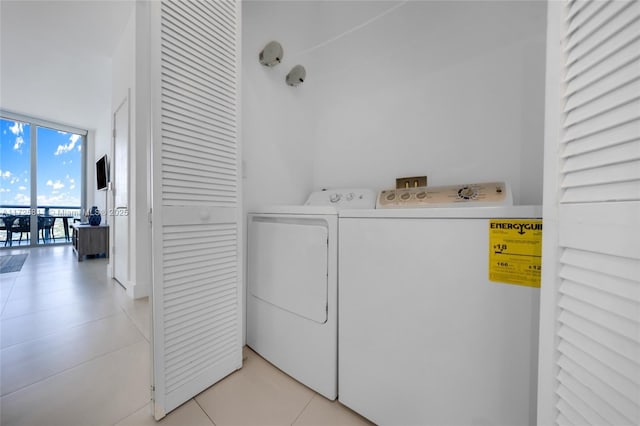 laundry area with light tile patterned floors, separate washer and dryer, and laundry area