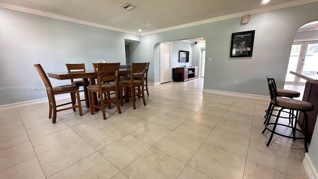 tiled dining area featuring crown molding