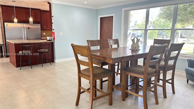 tiled dining room with a wealth of natural light and crown molding