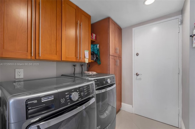 washroom with washer and dryer, cabinet space, and baseboards