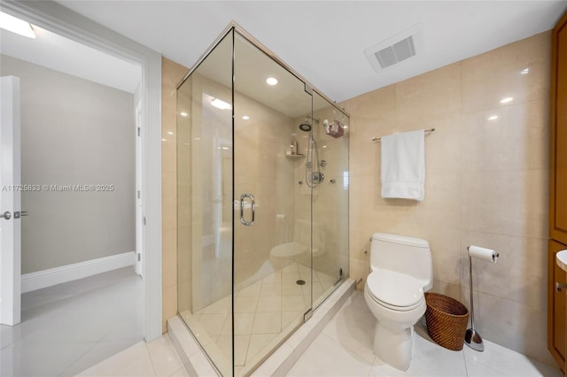 bathroom featuring visible vents, a shower stall, tile walls, toilet, and tile patterned floors