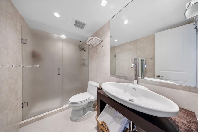 bathroom featuring tile walls, recessed lighting, visible vents, and a shower stall