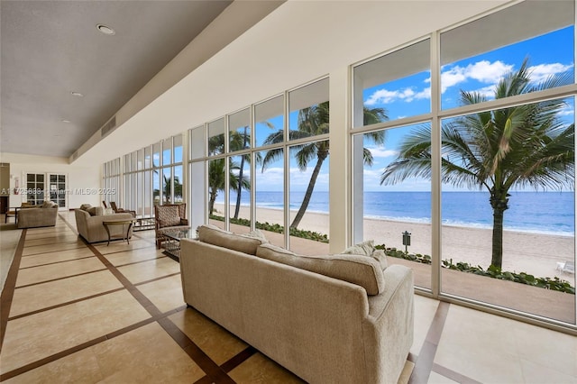 living room featuring a view of the beach, visible vents, and a water view