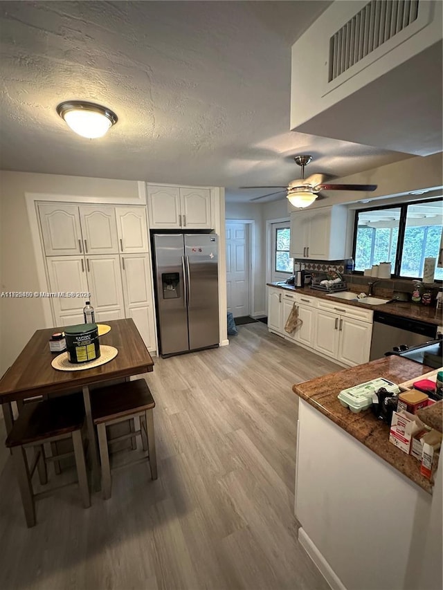 kitchen featuring white cabinets, stainless steel appliances, and a textured ceiling