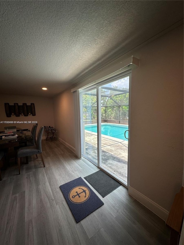 doorway to outside featuring a textured ceiling and hardwood / wood-style flooring