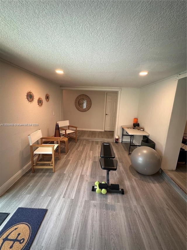 exercise area featuring a textured ceiling and hardwood / wood-style floors