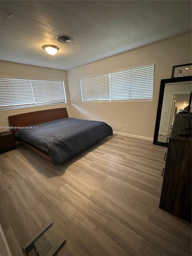 bedroom featuring a textured ceiling and hardwood / wood-style floors