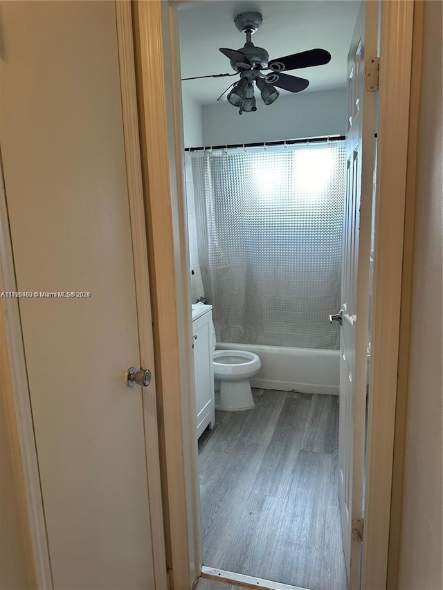 full bathroom with toilet, vanity, ceiling fan, hardwood / wood-style floors, and shower / tub combo