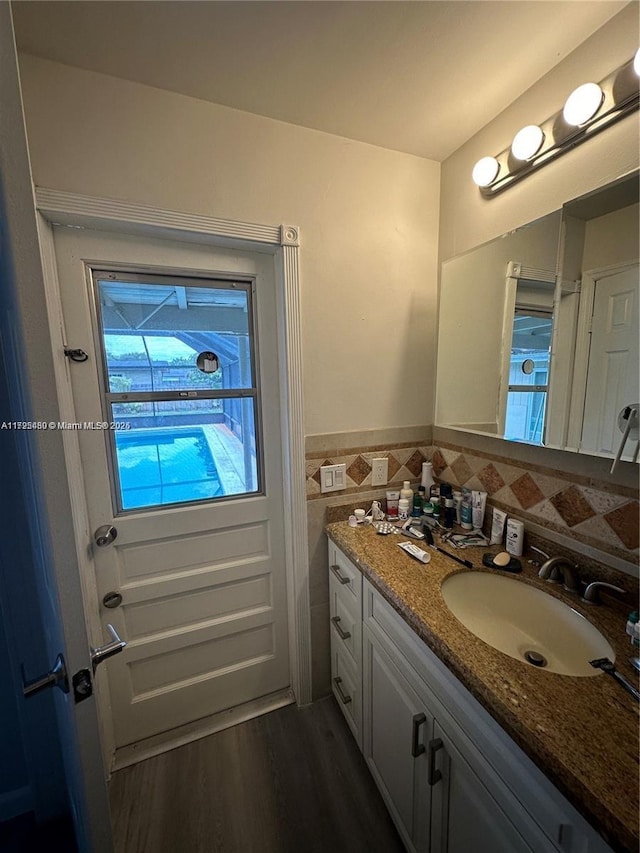 bathroom with vanity, tile walls, and wood-type flooring