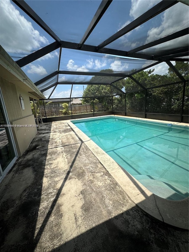 view of swimming pool with a lanai and a patio