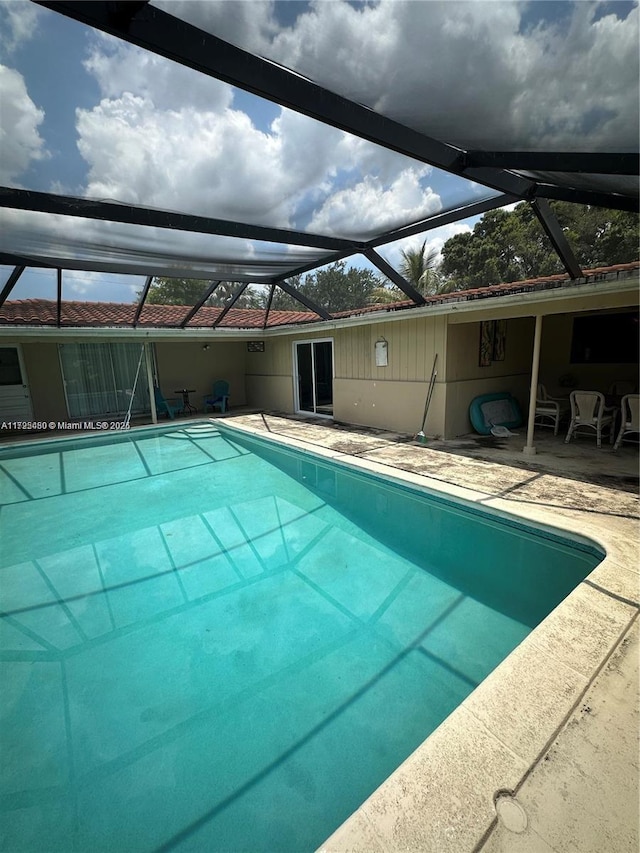 view of swimming pool featuring a lanai and a patio area