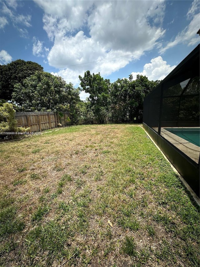 view of yard with glass enclosure