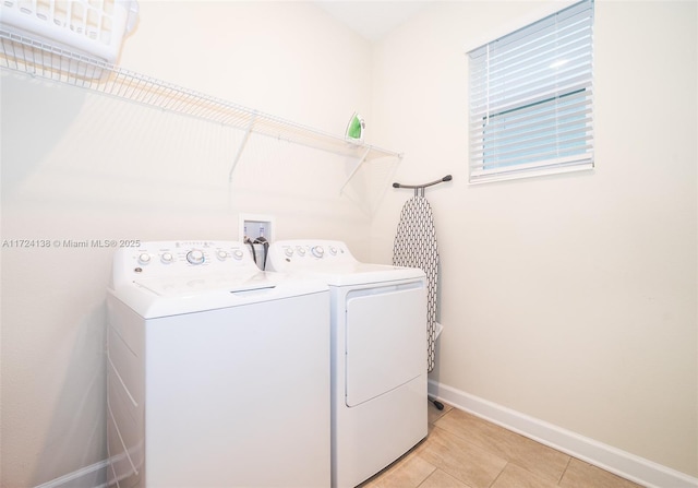 clothes washing area featuring light tile patterned floors and separate washer and dryer