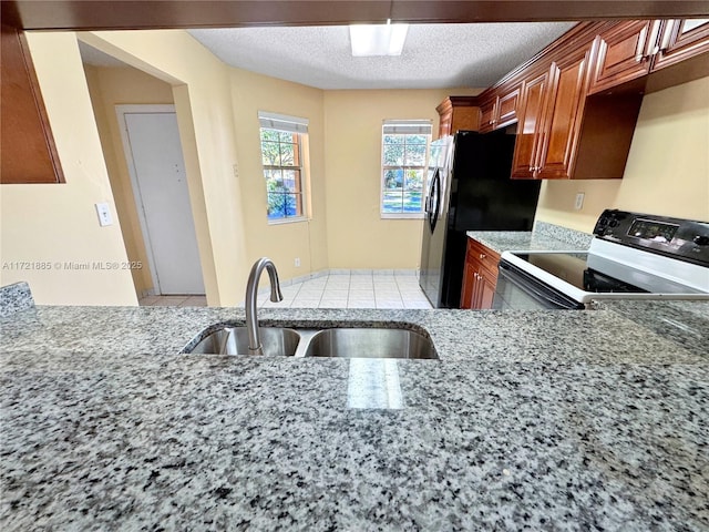 kitchen featuring a textured ceiling, black appliances, and sink