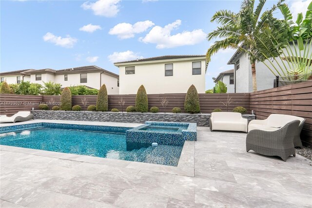 view of pool featuring a patio area, a fenced backyard, and a pool with connected hot tub