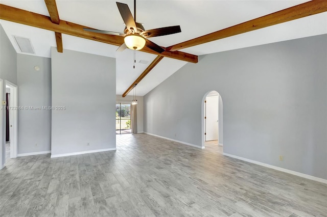 spare room featuring light hardwood / wood-style floors, ceiling fan, and vaulted ceiling with beams