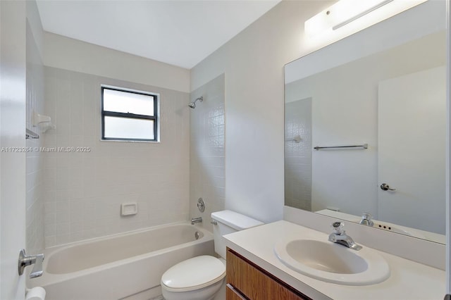 full bathroom featuring toilet, tiled shower / bath, and vanity