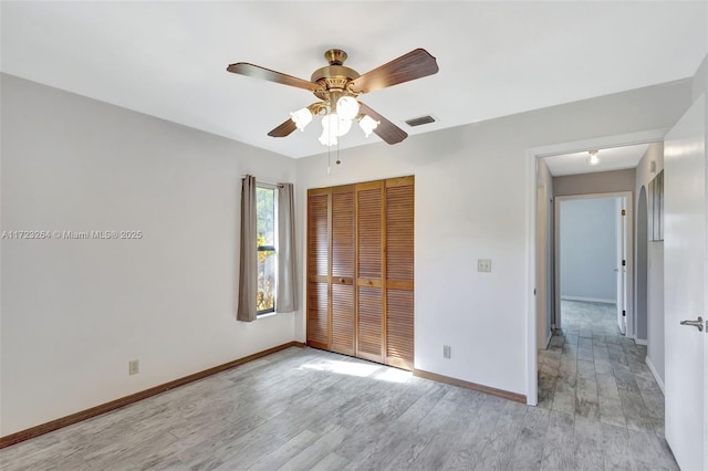 unfurnished bedroom with ceiling fan, a closet, and light hardwood / wood-style floors