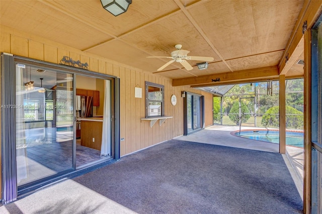 view of patio / terrace with ceiling fan, glass enclosure, and an indoor pool