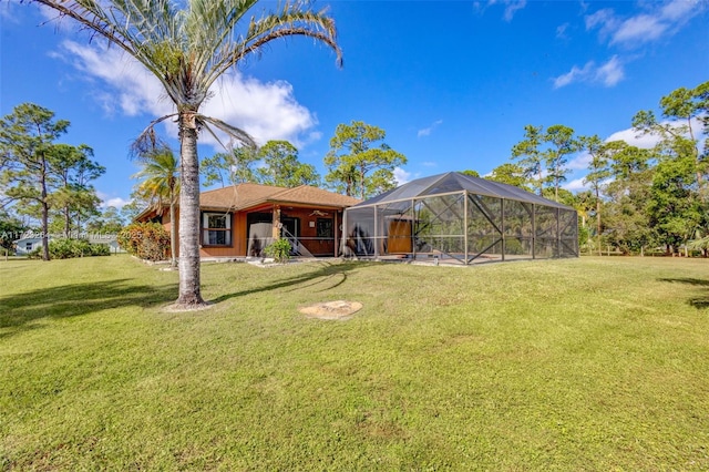 rear view of property with a lanai and a lawn