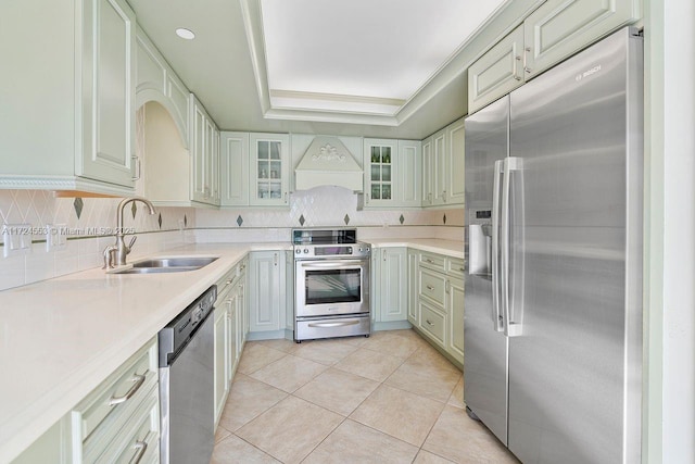 kitchen with custom exhaust hood, a raised ceiling, appliances with stainless steel finishes, light tile patterned floors, and sink