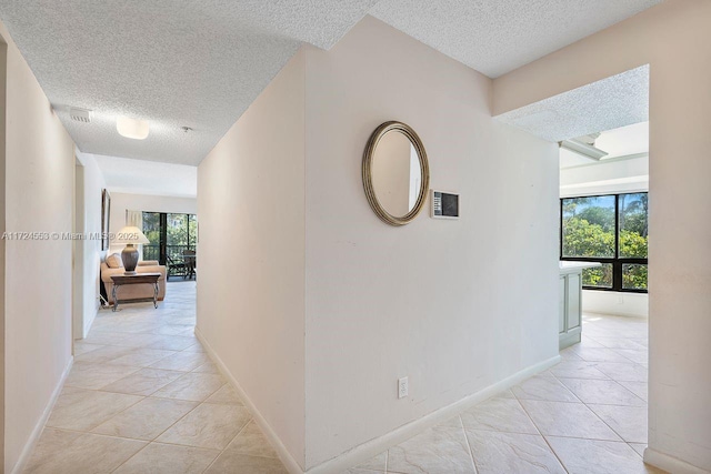 hall featuring a textured ceiling and light tile patterned floors