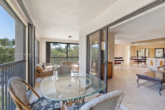 sunroom / solarium featuring a notable chandelier